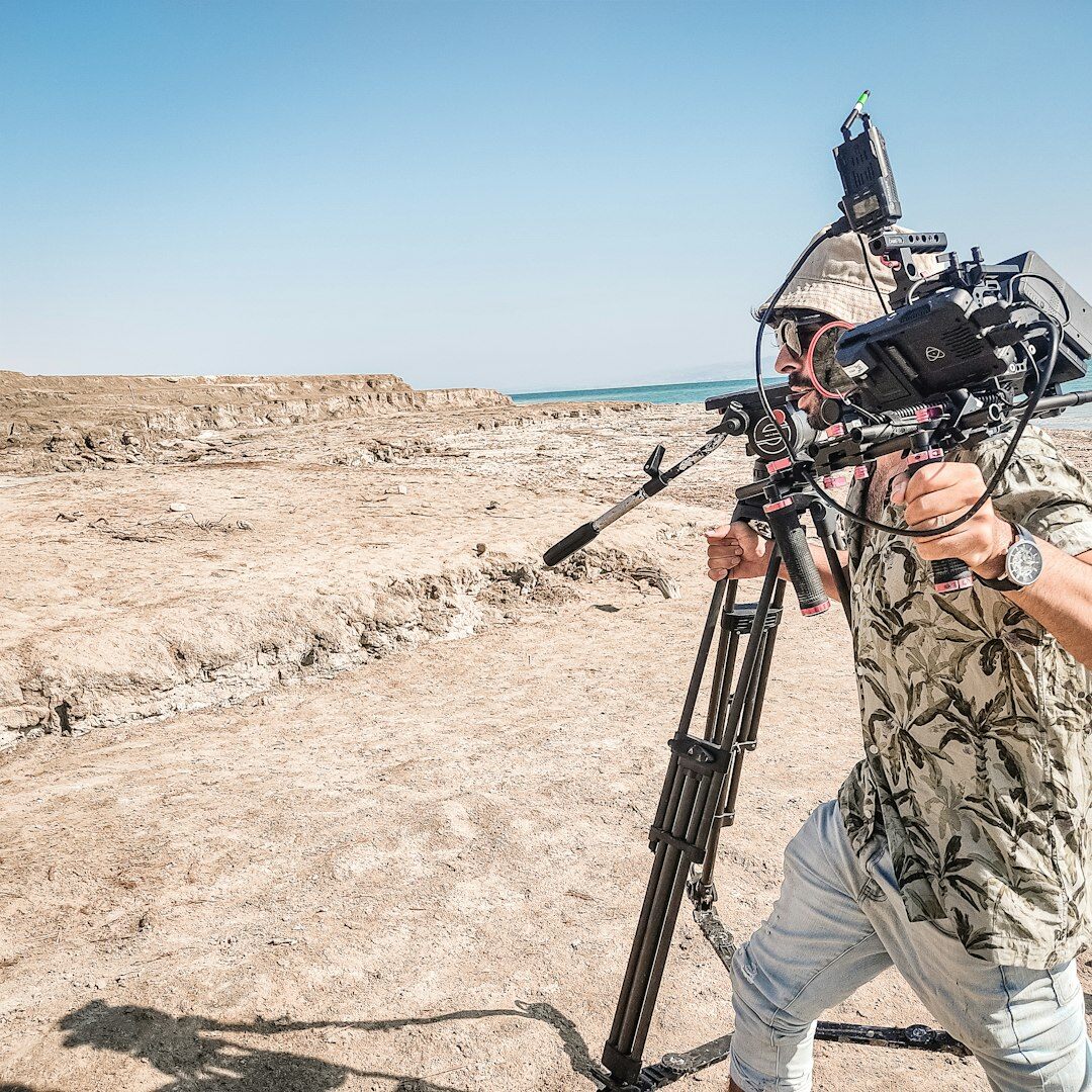 Camera operator adjusting a gimbal rig before filming